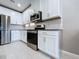 Kitchen with stainless steel appliances, granite counters, white cabinets and tile backsplash at 10347 Heron Hideaway Loop, Land O Lakes, FL 34638
