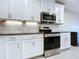 View of the kitchen featuring white cabinets, stainless steel appliances, and granite countertops at 10347 Heron Hideaway Loop, Land O Lakes, FL 34638