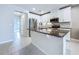 Bright kitchen featuring granite counters, stainless steel appliances, white cabinets, and tile flooring at 10347 Heron Hideaway Loop, Land O Lakes, FL 34638