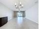 Expansive living room with light tile flooring, chandelier, and sliding glass doors at 10347 Heron Hideaway Loop, Land O Lakes, FL 34638