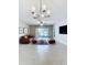 Well-lit living room with modern chandelier, tile flooring and sliding glass doors to the exterior at 10347 Heron Hideaway Loop, Land O Lakes, FL 34638