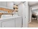 Organized laundry room includes a washer, dryer, storage cabinets, and decorative elements at 10412 White Lake Ct, Tampa, FL 33626