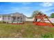 Spacious backyard featuring a large screened patio, a swing set, a slide, and lush green grass at 11123 Silver Dancer Dr, Riverview, FL 33579