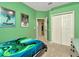 Green bedroom with themed artwork, double closet, and views of the hallway at 11123 Silver Dancer Dr, Riverview, FL 33579