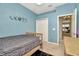 Blue bedroom with a black accent rug, view of a chandelier through the open doorway, and unique phases-of-the-moon decor at 11123 Silver Dancer Dr, Riverview, FL 33579