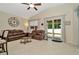 Bright living room with tile floors, comfortable leather seating, and easy access to the outdoor lanai and kitchen at 11123 Silver Dancer Dr, Riverview, FL 33579