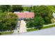Aerial view of a single Gathering home with red roof, long driveway, and mature trees at 11334 Winwood Pl # 11334, Port Richey, FL 34668