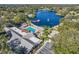 Aerial perspective of the community clubhouse with a pool, pond, and recreational facilities amidst lush trees at 11334 Winwood Pl # 11334, Port Richey, FL 34668
