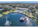 Aerial shot of a community clubhouse featuring a pond with fountain, pool, and surrounding greenery at 11334 Winwood Pl # 11334, Port Richey, FL 34668