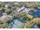 Overhead view of the community clubhouse offering a pool, pond, tennis courts, and verdant landscaping at 11334 Winwood Pl # 11334, Port Richey, FL 34668