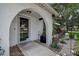 Arched entryway featuring a storm door, plants, and a Welcome mat at 11334 Winwood Pl # 11334, Port Richey, FL 34668