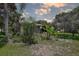 Well-manicured backyard featuring lush landscaping and a banana tree near the house at 11334 Winwood Pl # 11334, Port Richey, FL 34668