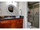 Bathroom features a vanity, granite countertops, decorative mirror, and glass-enclosed shower at 11334 Winwood Pl # 11334, Port Richey, FL 34668