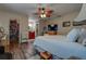 Comfortable bedroom featuring walk-in closet and ensuite bathroom access, ceiling fan, and warm, wood-look floors at 11334 Winwood Pl, Port Richey, FL 34668