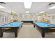 A billiard room with two Diamond pool tables and comfortable seating for players at 11334 Winwood Pl # 11334, Port Richey, FL 34668