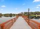 Picturesque community pier stretching over a tranquil lake under a clear blue sky at 11334 Winwood Pl # 11334, Port Richey, FL 34668