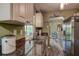 Bright kitchen with a double basin sink, contrasting counter tops and hardwood-style flooring, with views into dining area at 11334 Winwood Pl # 11334, Port Richey, FL 34668