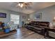Inviting living room with a large leather couch, ceiling fan, and wood-look flooring at 11334 Winwood Pl # 11334, Port Richey, FL 34668
