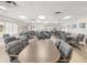 Bright meeting room with multiple tables, upholstered chairs, ceiling fans, and tile flooring at 11334 Winwood Pl # 11334, Port Richey, FL 34668