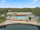 Aerial view of a community swimming pool with lounging and dining areas by a lake at 11334 Winwood Pl # 11334, Port Richey, FL 34668