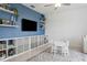 Stylish bonus room with bright blue accent wall, integrated shelving, and furniture, ideal for play at 11693 Lavender Loop, Spring Hill, FL 34609