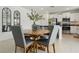 Inviting dining area with a wooden round table, upholstered chairs, and a view into the modern kitchen at 11693 Lavender Loop, Spring Hill, FL 34609