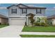 Charming two-story home featuring a well-manicured lawn, attached two-car garage, and appealing curb appeal at 11693 Lavender Loop, Spring Hill, FL 34609