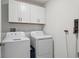 This laundry room features a full size washer and dryer, and plenty of cabinet space for storage at 11693 Lavender Loop, Spring Hill, FL 34609