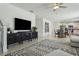 Bright living room with a stylish entertainment center, ceiling fan and an open floor plan to the dining area at 11693 Lavender Loop, Spring Hill, FL 34609