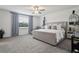 Serene main bedroom with large bed, plush carpeting, and soft natural light from the large window with blue curtains at 11693 Lavender Loop, Spring Hill, FL 34609