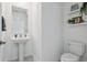 Elegant powder room with pedestal sink, tiled floors, and wall decorations, creating a clean and welcoming space at 11693 Lavender Loop, Spring Hill, FL 34609