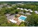 Community aerial featuring a pool, clubhouse, tennis courts, and lush green trees at 11805 Raintree Lake Ln # A, Tampa, FL 33617