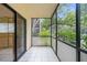 Charming screened balcony with neutral tile flooring and a serene view of the surrounding greenery at 11805 Raintree Lake Ln # A, Tampa, FL 33617