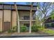 Condo exterior showcasing private screened balconies and well-maintained grounds, shaded by mature trees at 11805 Raintree Lake Ln # A, Tampa, FL 33617