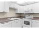 Galley kitchen with white cabinets, laminate countertops, and white appliances at 11805 Raintree Lake Ln # A, Tampa, FL 33617