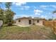 Backyard showcasing the property's exterior, including a lawn, wooden fence, and tidy landscaping at 1305 Marion S Dr, St Petersburg, FL 33707