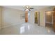 Sunny bedroom featuring ceiling fan, terrazzo flooring, and ensuite bathroom at 1305 Marion S Dr, St Petersburg, FL 33707