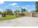 Exterior view featuring a well-manicured lawn, mature palms, and a single car garage at 1305 Marion S Dr, St Petersburg, FL 33707