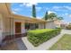 Charming front exterior with a quaint porch, lush hedges, and a decorative front door at 1305 Marion S Dr, St Petersburg, FL 33707