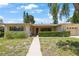 Charming single-story home with a well-manicured lawn, lush shrubbery, and a welcoming walkway leading to the front door at 1305 Marion S Dr, St Petersburg, FL 33707