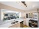 Bright kitchen featuring white cabinets, subway tile backsplash, and a breakfast bar overlooking the living room at 1305 Marion S Dr, St Petersburg, FL 33707