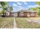 Exterior of the home featuring a large backyard, storage shed, and well-maintained landscaping at 1511 East Emma St. E St, Tampa, FL 33610