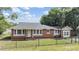 Front exterior of the home with brick facade, multi-pane windows, and a chain link fence at 1511 East Emma St. E St, Tampa, FL 33610
