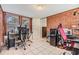 Home office featuring exposed brick walls, tile floors, and two desk setups at 1511 Emma E St, Tampa, FL 33610