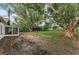 Large backyard with mature trees and a screened-in patio, and a bird bath at 1558 Cottonwood Ter, Dunedin, FL 34698