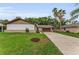Well-maintained single-story home with a lush lawn, mature trees, and a long driveway at 1558 Cottonwood Ter, Dunedin, FL 34698