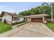 Charming single-story home with a well-manicured lawn and a two-car attached garage at 1558 Cottonwood Ter, Dunedin, FL 34698