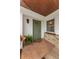 Charming front entrance featuring a tiled porch, lush landscaping, and an olive-green door at 1558 Cottonwood Ter, Dunedin, FL 34698