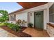 Inviting front entrance with a tiled porch, lush landscaping, and a painted door at 1558 Cottonwood Ter, Dunedin, FL 34698