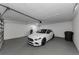 A clean, two-car garage features a new, white Mercedes-Benz at 1558 Cottonwood Ter, Dunedin, FL 34698